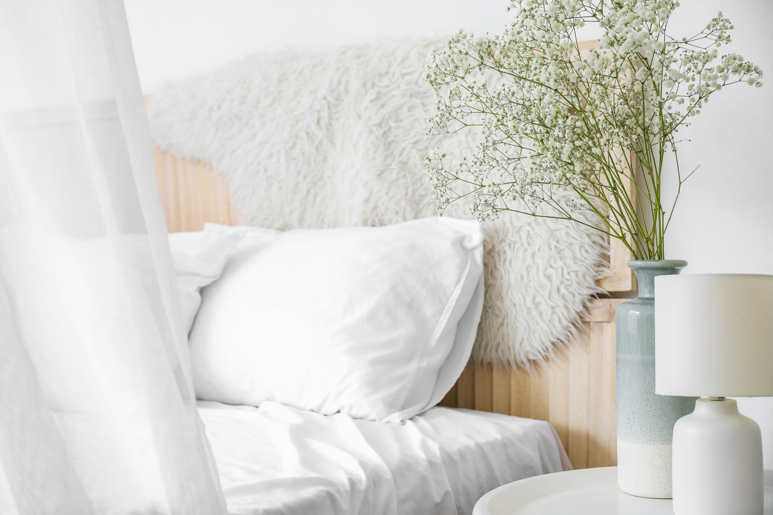 Vase with Flowers and Lamp on Side Table in Bedroom